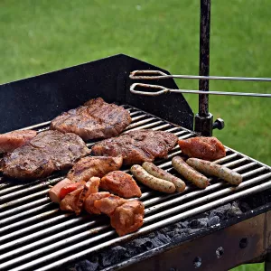 Multiple types of meat sit an an outdoor grill