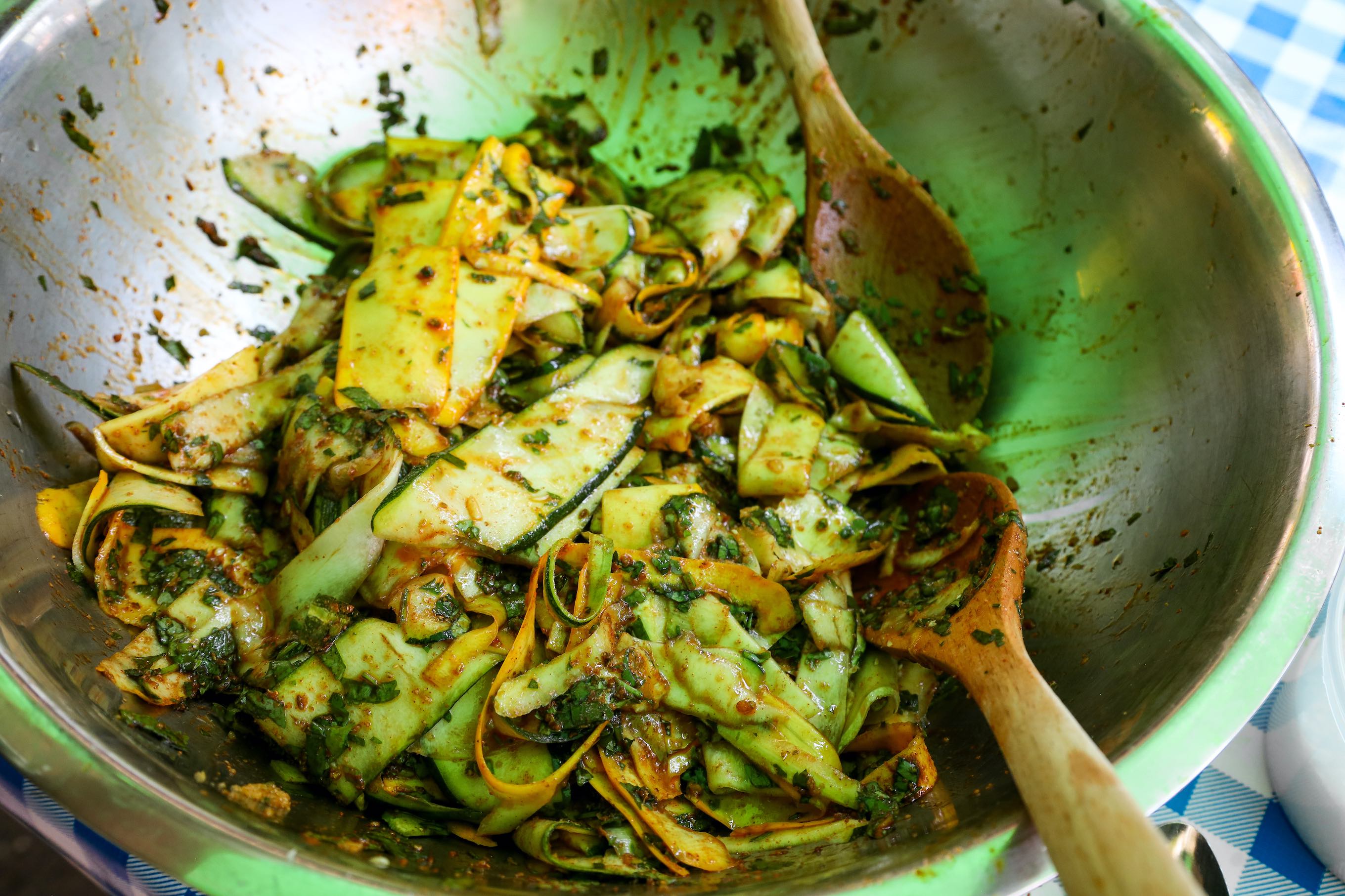 Summer squash noodles mixed with chermoula in metal bowl