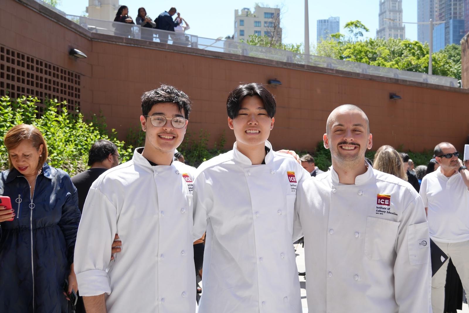 ICE graduate Steven Gao smiles with two other graduates at ICE's commencement ceremony