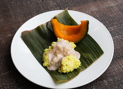 Kabocha squash wedge on a plate with coconut sticky rice