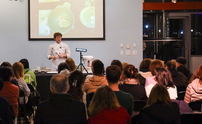 Chef Kierin in front of audience talking about cookies