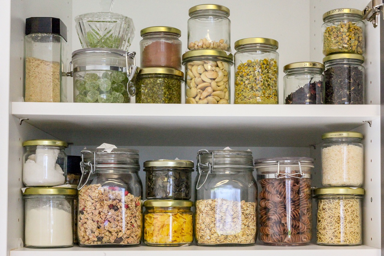 Jars of various dried goods on two pantry shelves