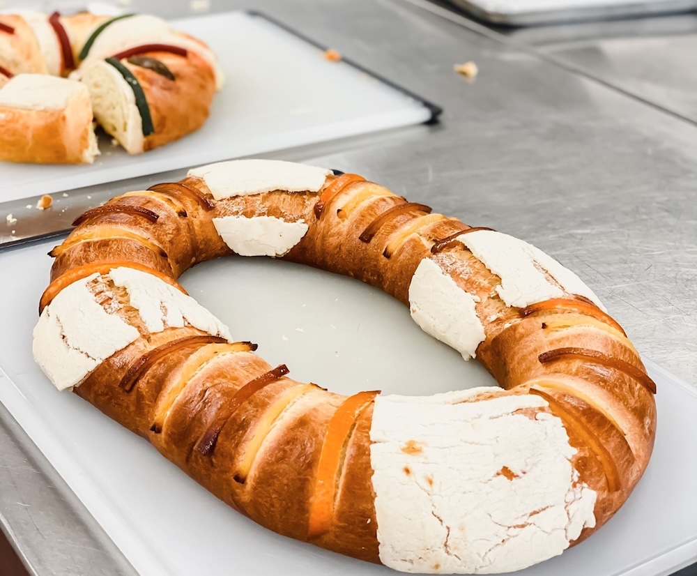 Rosca de Reyes, a circular bread, sits on a white cutting board