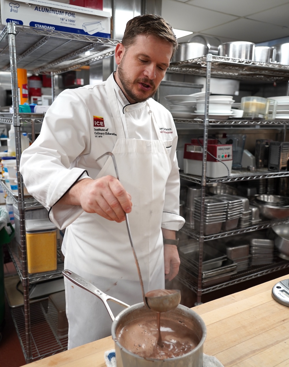 Chef Shawn Matijevich pours hot chocolate from a ladle into a pot