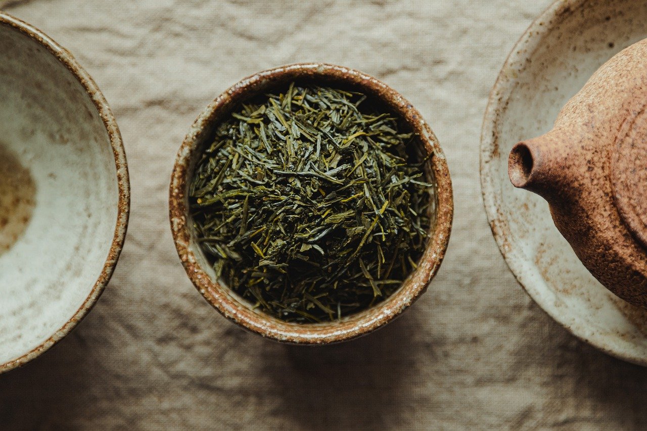 Bird's eye view of bowl of loose green tea leaves. 