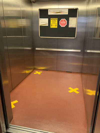The elevator indicates where three people can stand distanced.