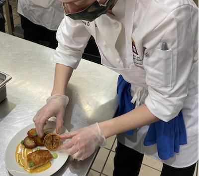 Micaela plating food in class at ICE