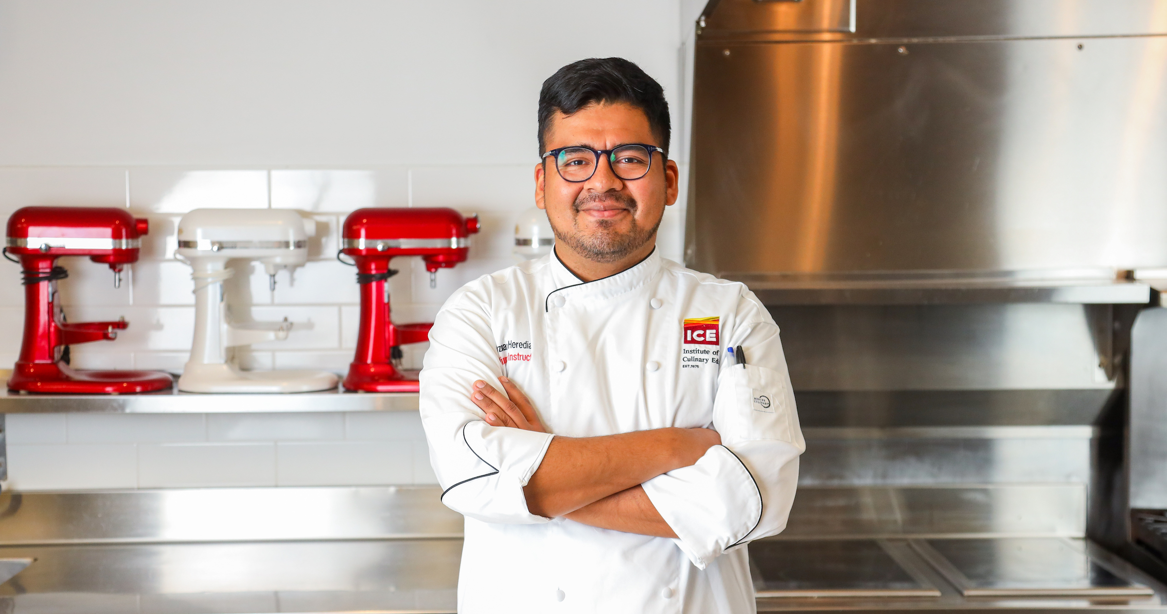 Chef-Instructor Ozmar Heredia stands in a kitchen smiling
