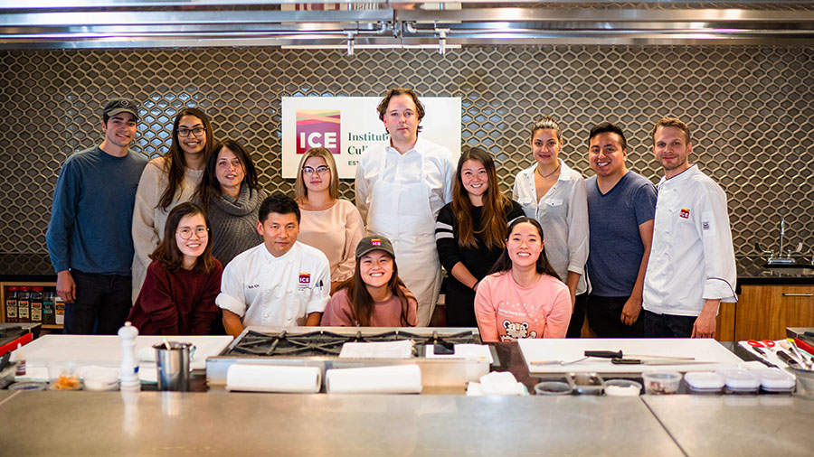 Chef Paul Liebrandt poses with students and chefs after an Elite Chef Series demonstration at ICE.