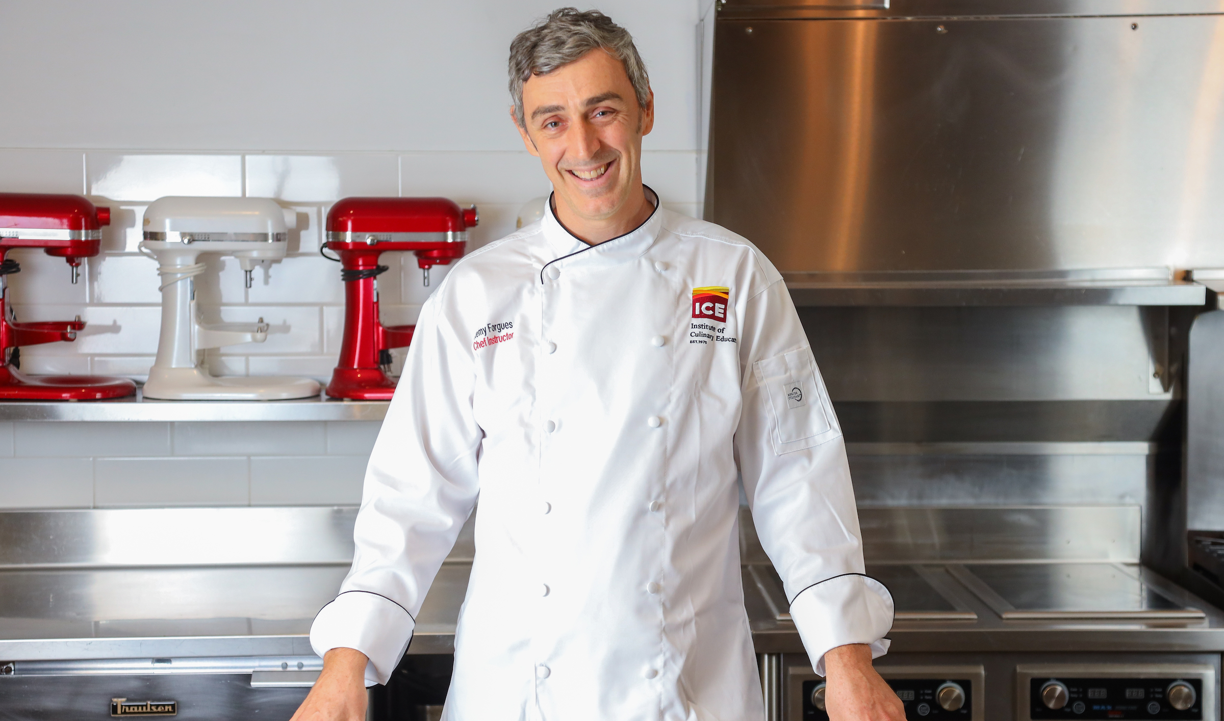 Chef-Instructor Remy Forgues stands in a kitchen smiling