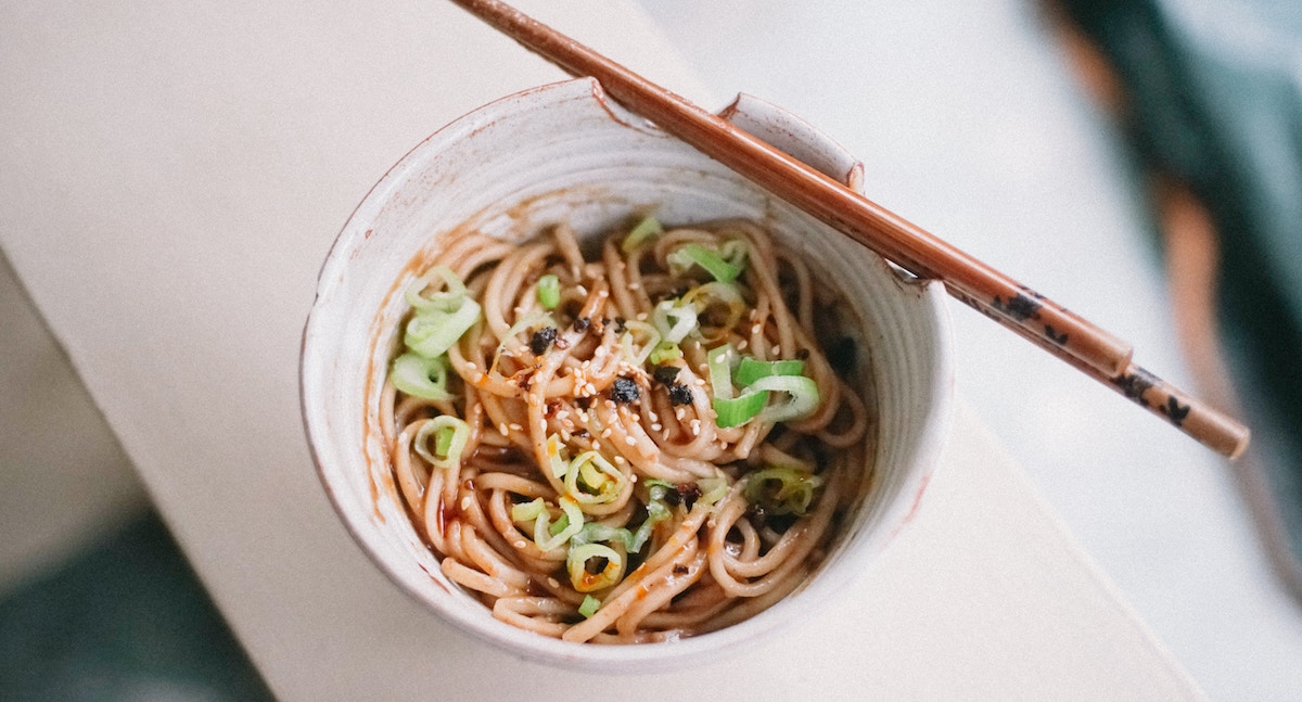 Udon noodles sit in a white ceramic bowl