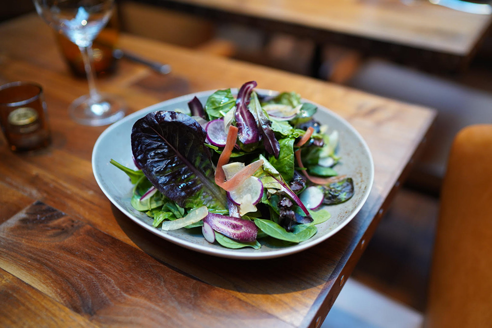 Society Cafe's Market Green Salad features radish and apple cider vinaigrette.