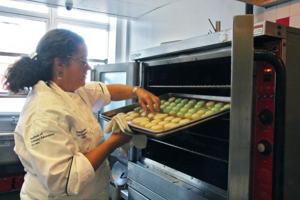 Chef Kathryn checks on macarons baking in the oven.