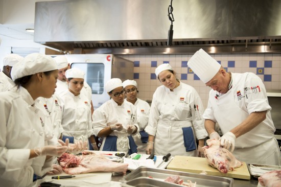 ICE instructor Ted Seigel teaches students to debone a leg of lamb.