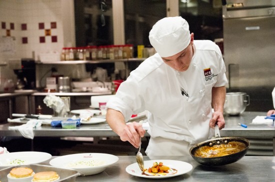 New York culinary student plating a dish from a hot pan