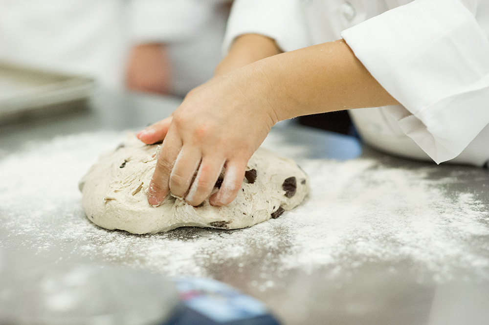 A student shapes dough in an Artisan Bread Baking class at ICE.