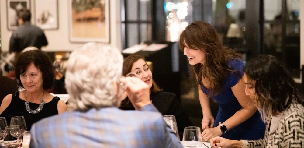 Amy Baer Robinson speaks with guests at an event she hosted