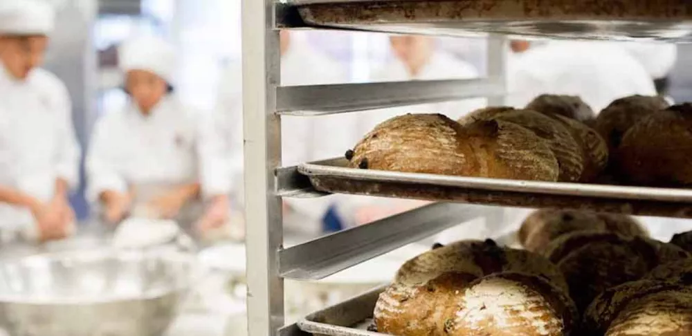 Freshly baked bread cooling on a speed rack in professional kitchen