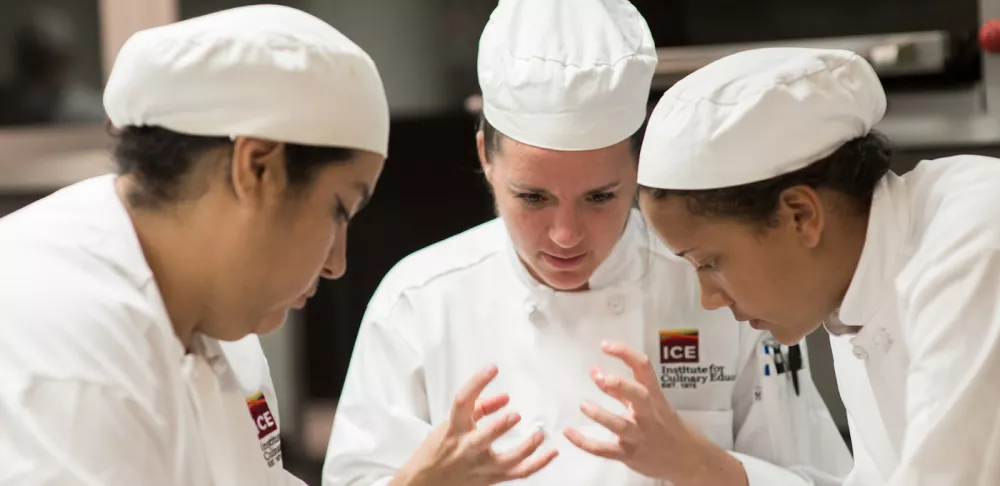 cooks in kitchen discussing what to do with their food waste