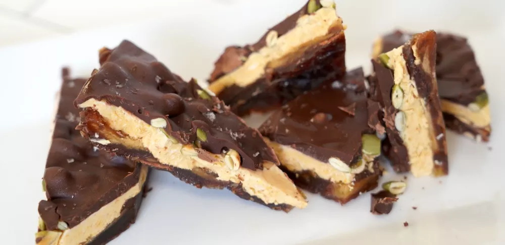 Date bark covered in chocolate on a white plate