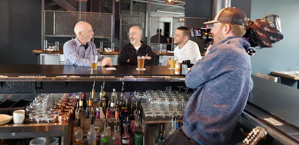 The show "Dom Eats Local" films a segment in a bar.