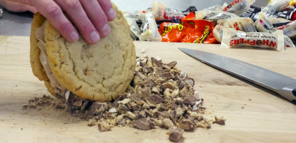 Chef Penny rolls her ice cream sandwich in candy crumbs.