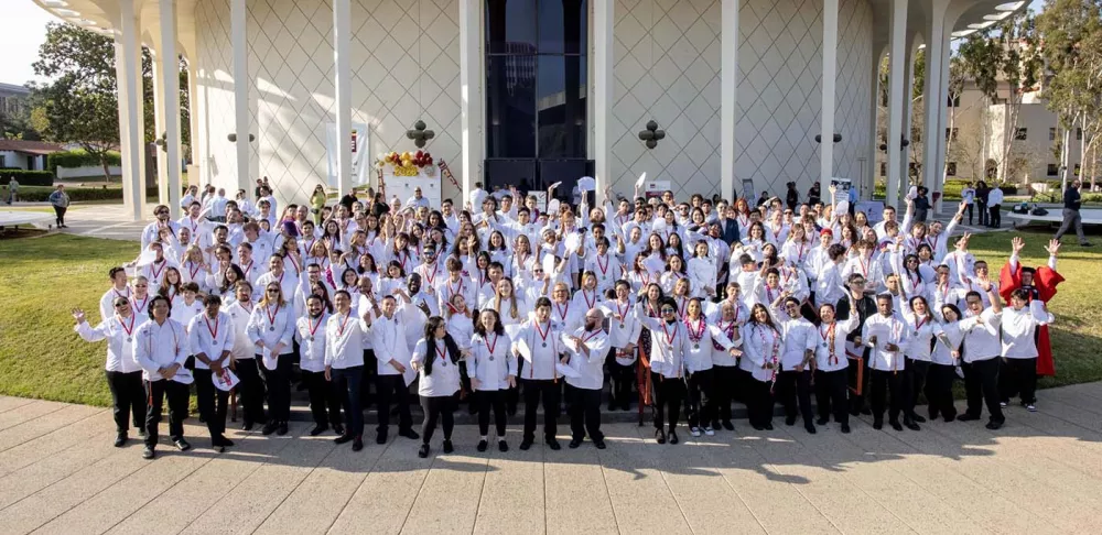 A group of students smile at the ICE Los Angeles 2023 Commencement ceremony