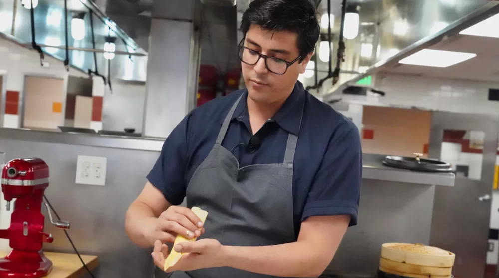 Chef Jesus "Chuy" Cervantes folds a corn tamale