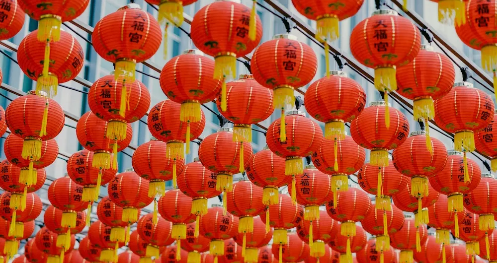 Rows of red lanterns hang suspended from wooden support beams