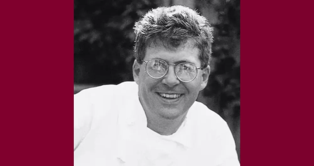 ICE graduate Steven Durfee, a man wearing circular glasses in a white chef's coat, smiles