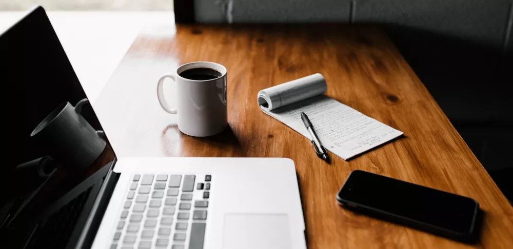 laptop with coffee cup and notebook