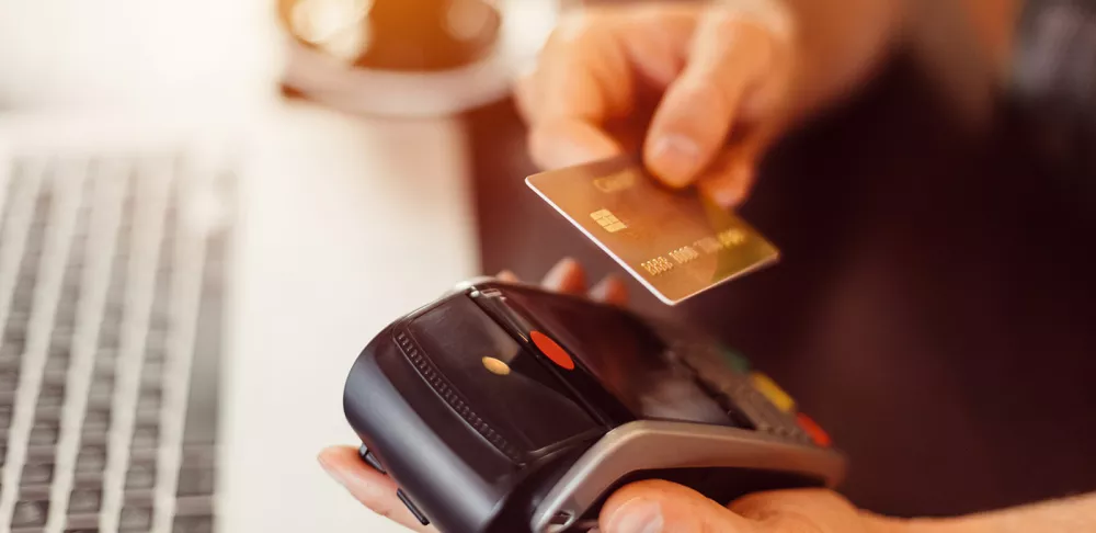 A hand readies a credit card for a transaction.