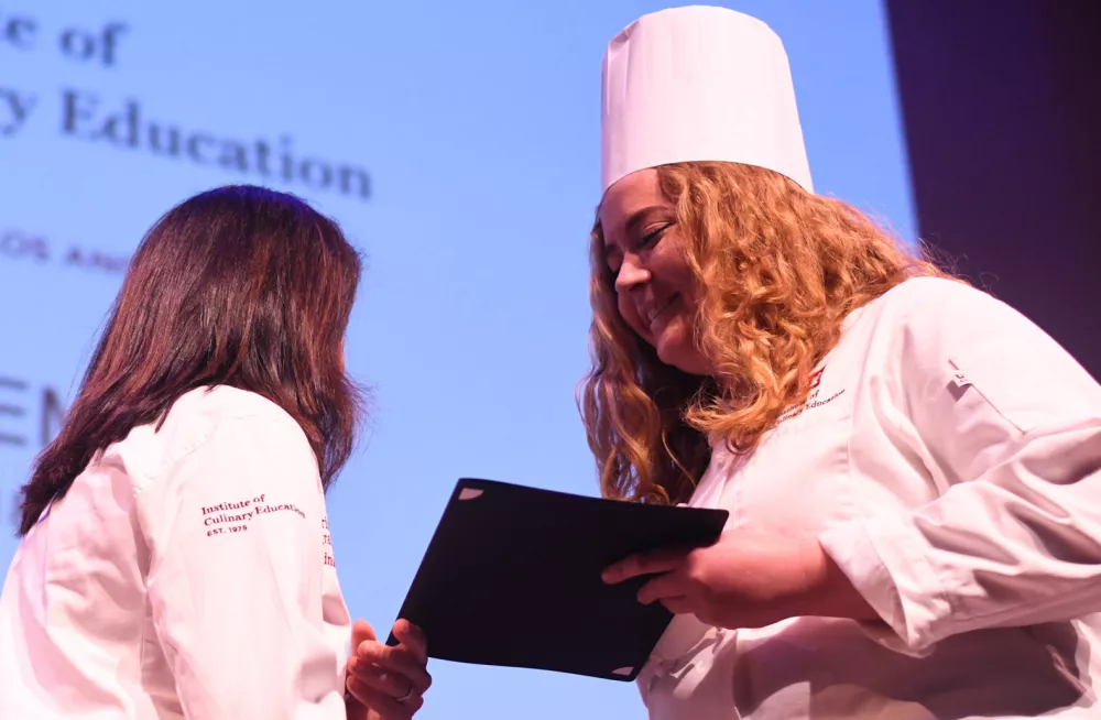 An ICE student receives a diploma at commencement