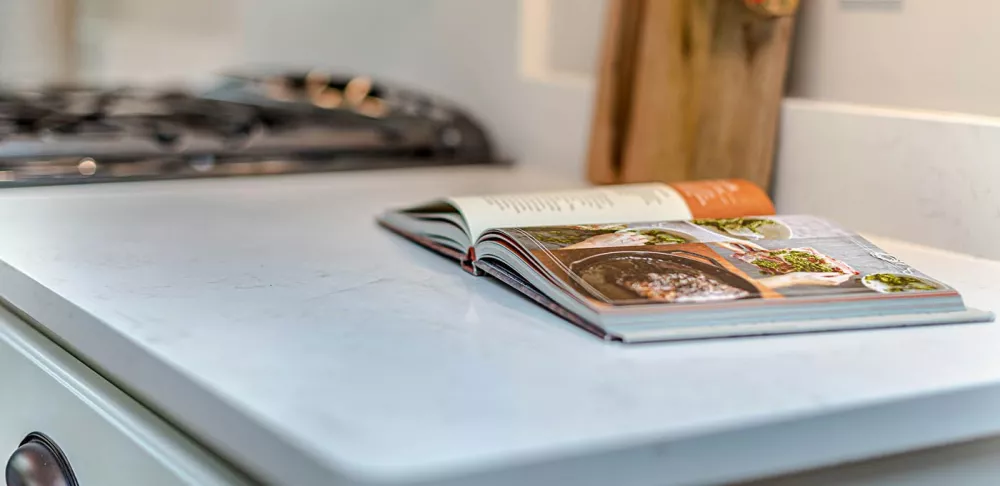 An open cookbook on a kitchen counter.