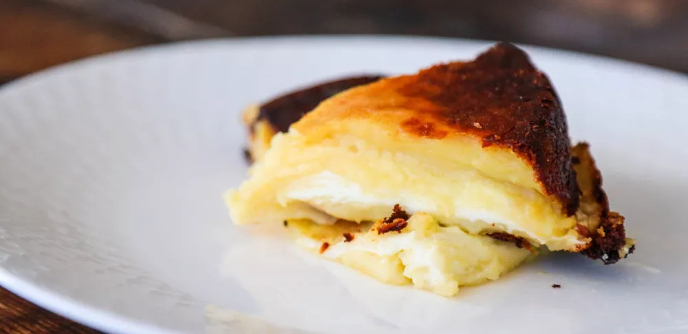 A piece of gatto di patate sits on a white plate