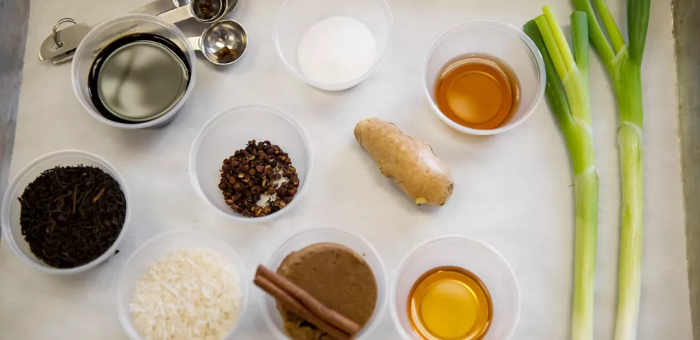 Mise en place ingredients on a sheet tray  including vinegars, spices, and seasonings