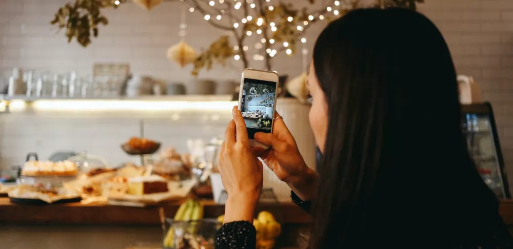 A woman takes a photo in a restaurant