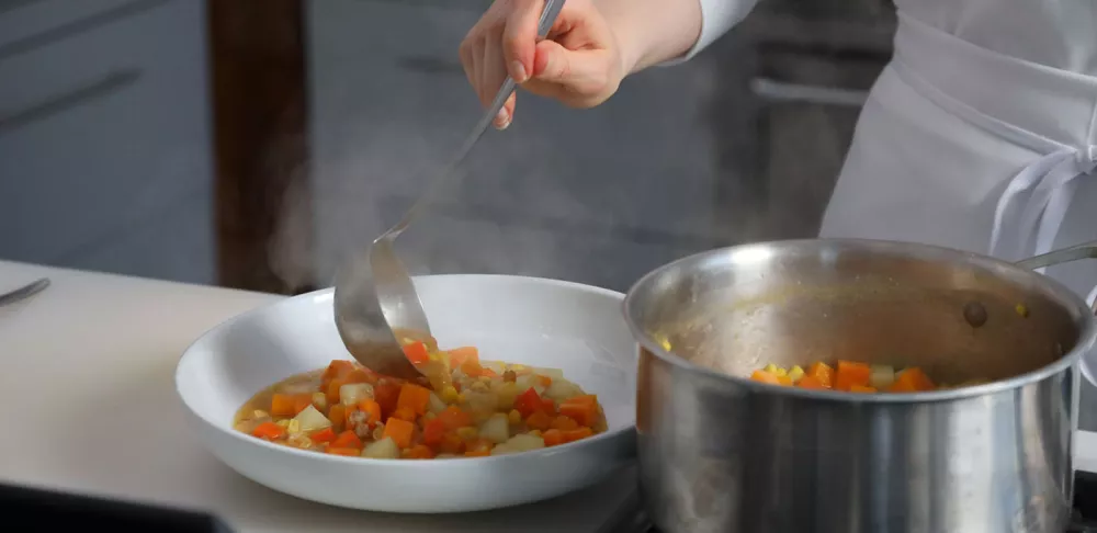 A student plates a meal for Plant-Based Culinary Arts online