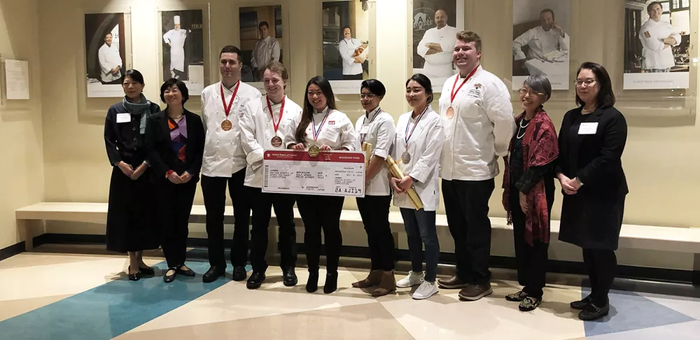 Amanda Lee holds her boarding pass prize after winning the United States of Umami Culinary Competition