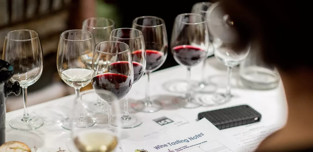 A white and red wine tasting is set up for a class.