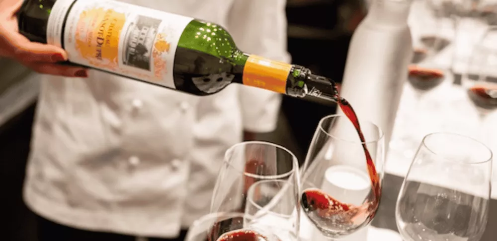 chef pouring red wine into glass