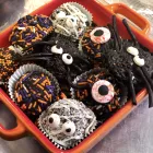 Chocolate Halloween fudge balls decorated with colorful sprinkles in an orange box