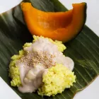 Kabocha squash wedge on a plate with coconut sticky rice