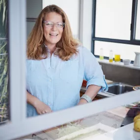 ICE graduate and food writer, cookbook author and recipe developer Adeena Sussman smiles wearing blue shirt and long brown hair.