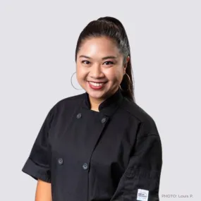 ICE Alumni Sugar Sungkamee smiles at the camera in a black chef jacket. Photo Credit: Louis P.