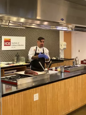 Chef Aaron Sanchez cooking in the demonstration kitchen at ICE's New York campus