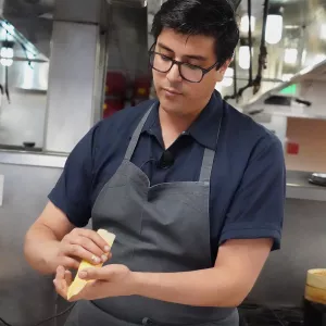 Chef Jesus "Chuy" Cervantes folds a corn tamale