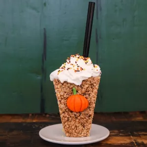 Crispy rice treats shaped into a coffee cup topped with whipped cream and straw