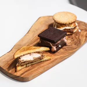 Three s'mores on wooden board