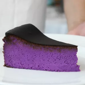 Purple ube Basque cheesecake on a white plate